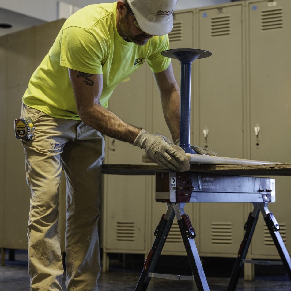 A worker assembling a bench in a locker room