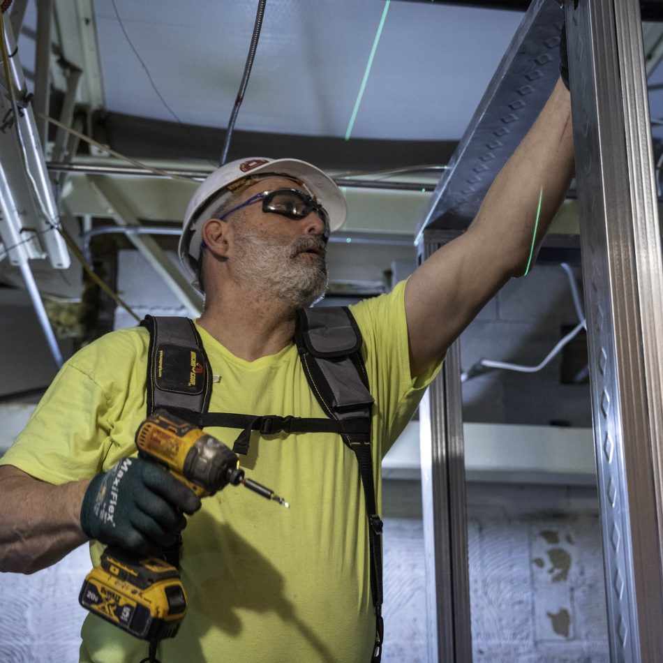 A CCB employee holding a drill