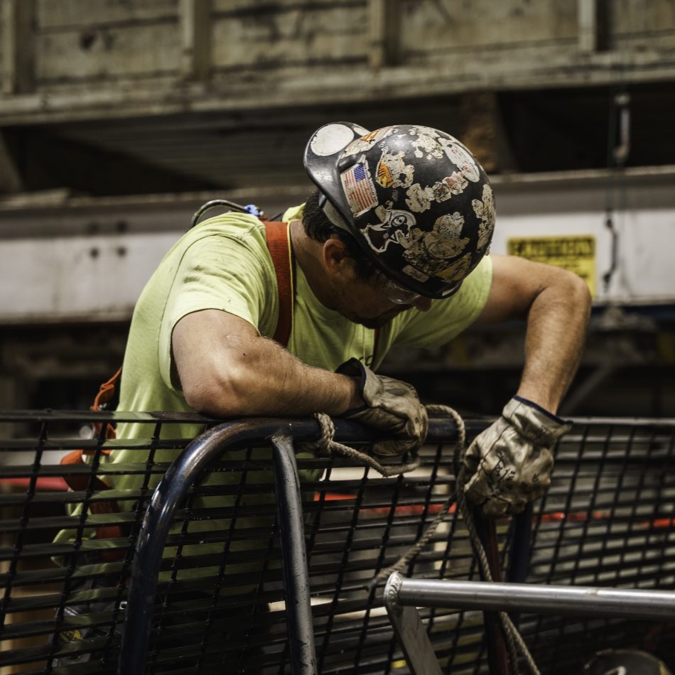 A worker attaching wires to metal