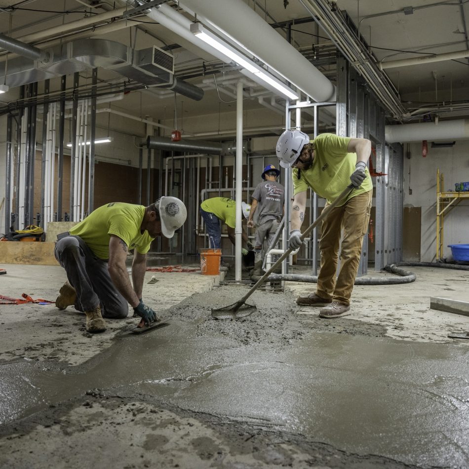 Two workers laying concrete