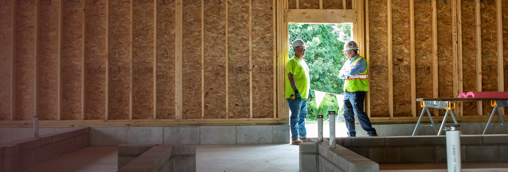 Two workers standing in a doorway talking